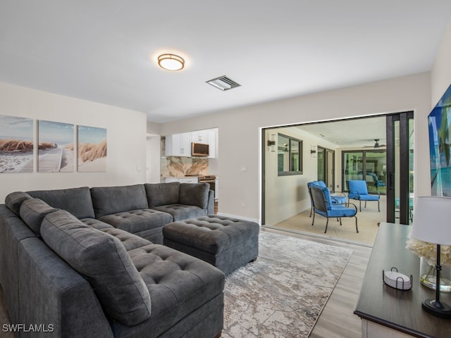 living room featuring ceiling fan and light hardwood / wood-style floors