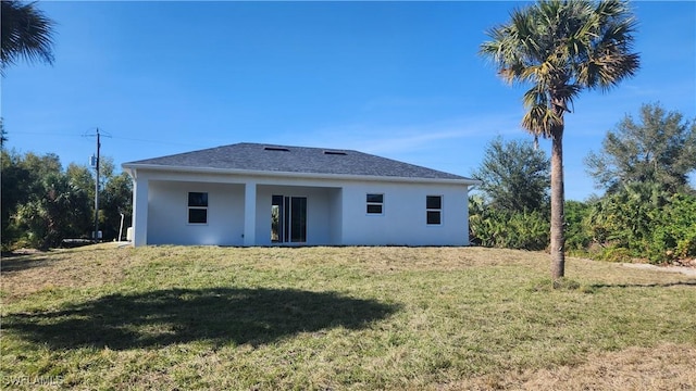 rear view of property featuring a lawn