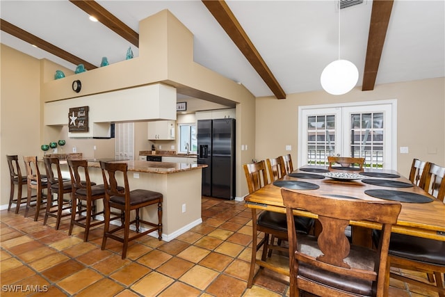 kitchen featuring white cabinets, lofted ceiling with beams, refrigerator with ice dispenser, kitchen peninsula, and light tile patterned flooring