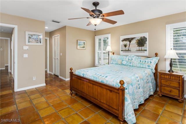 bedroom with a closet, tile patterned floors, and ceiling fan