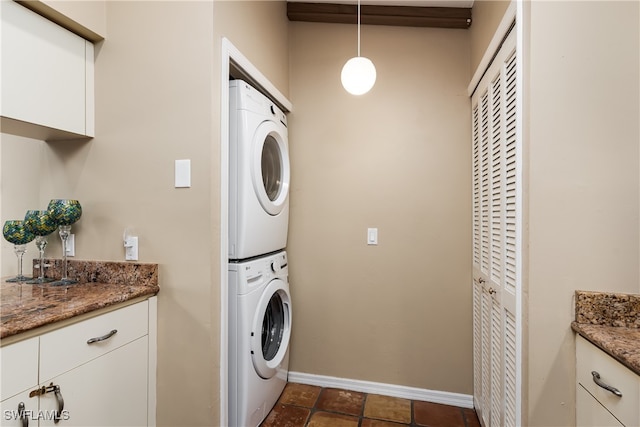 clothes washing area featuring stacked washing maching and dryer