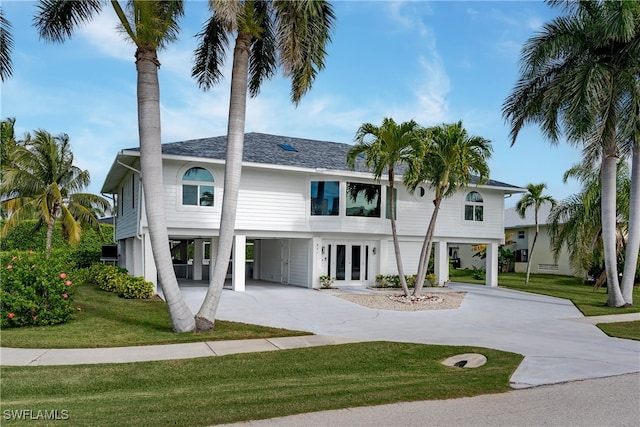 coastal inspired home with a front lawn and french doors