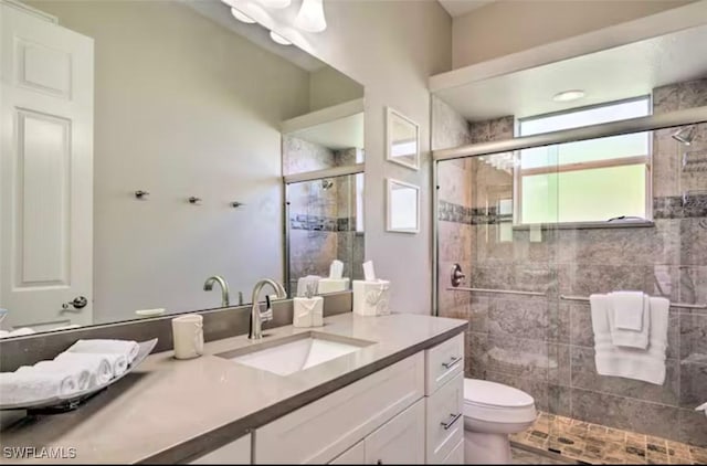 bathroom featuring vanity, toilet, and an enclosed shower