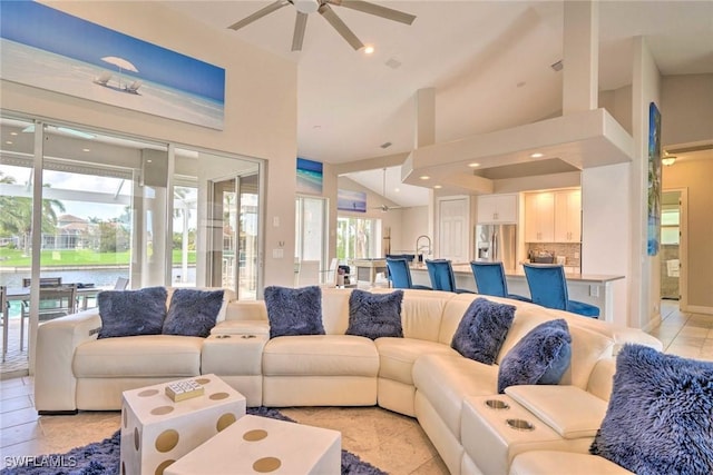 tiled living room featuring ceiling fan and high vaulted ceiling