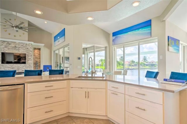 kitchen with white cabinets, ceiling fan, sink, and vaulted ceiling