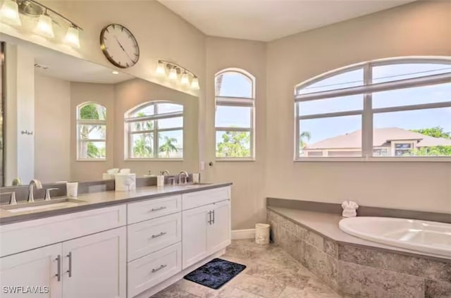 bathroom with vanity and tiled tub