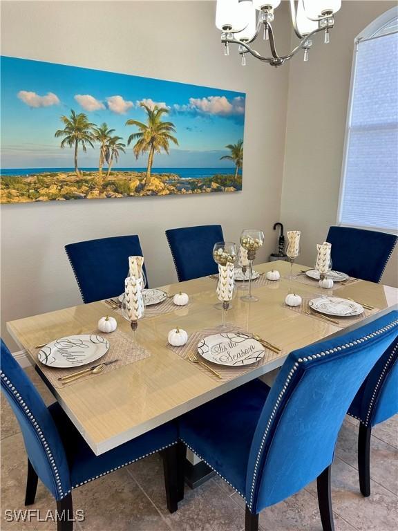 tiled dining space with a chandelier