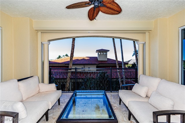 living room with a textured ceiling and ceiling fan