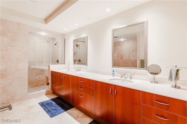 bathroom featuring tile patterned floors, a tile shower, and vanity