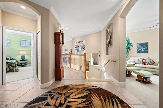 corridor with a wealth of natural light, crown molding, and light tile patterned flooring