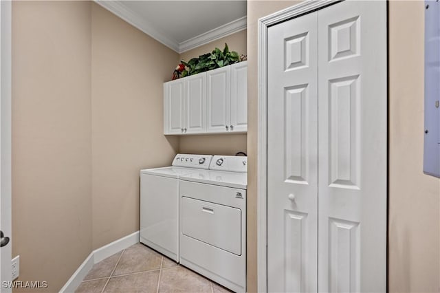 washroom featuring light tile patterned flooring, washing machine and clothes dryer, ornamental molding, and cabinets