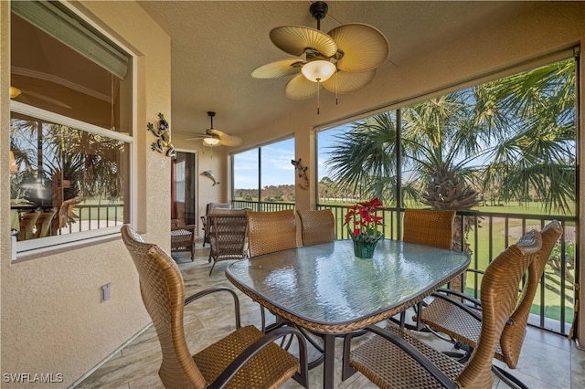 sunroom / solarium featuring ceiling fan