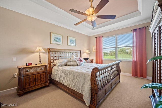 carpeted bedroom with crown molding, ceiling fan, and a raised ceiling