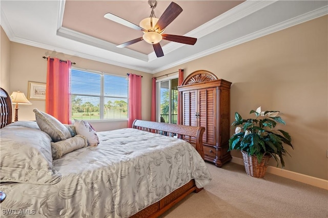 carpeted bedroom with ceiling fan, ornamental molding, and a tray ceiling