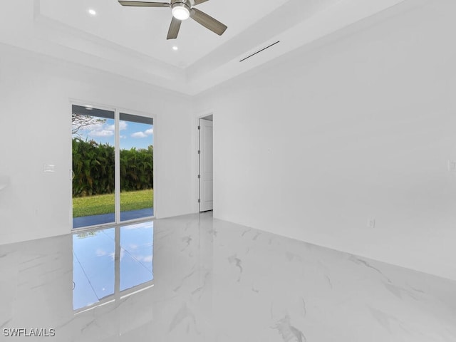 empty room with a tray ceiling and ceiling fan