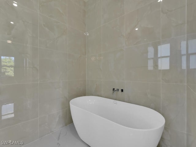 bathroom with a bath and tile walls