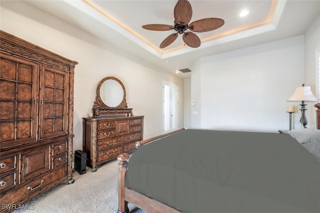 bedroom with light carpet, a tray ceiling, and ceiling fan