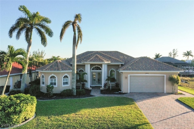 ranch-style home featuring a garage and a front lawn