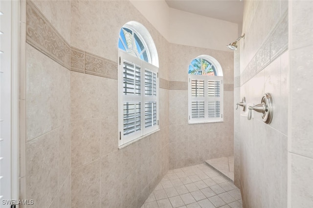 bathroom with tiled shower and a wealth of natural light