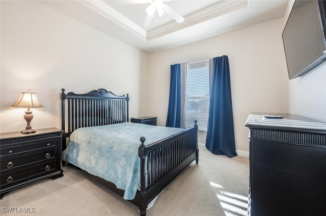 carpeted bedroom with ceiling fan, ornamental molding, and a raised ceiling