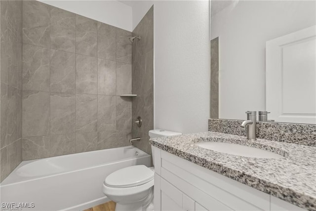 full bathroom featuring tiled shower / bath combo, toilet, and vanity