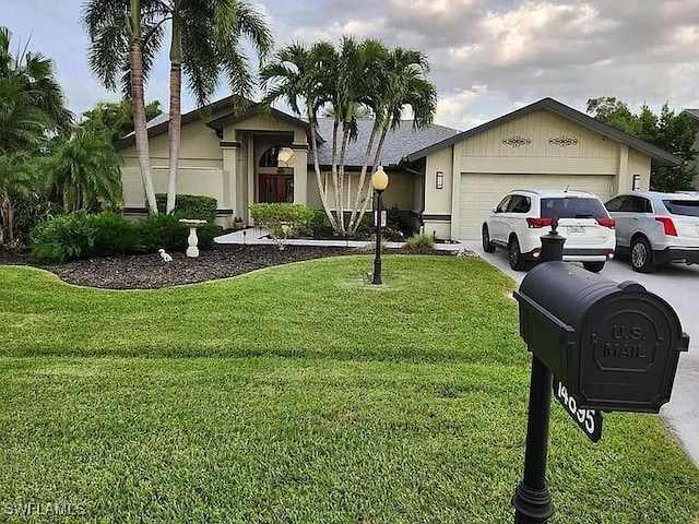 view of front of property with an attached garage, driveway, and a front yard