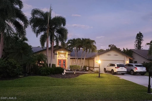 view of front of home with a lawn and a garage