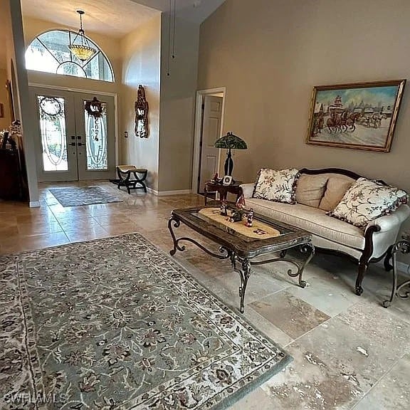 living room featuring french doors and high vaulted ceiling