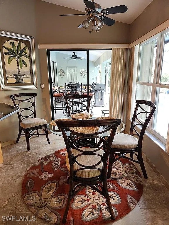 dining area featuring tile patterned floors, ceiling fan, a healthy amount of sunlight, and lofted ceiling