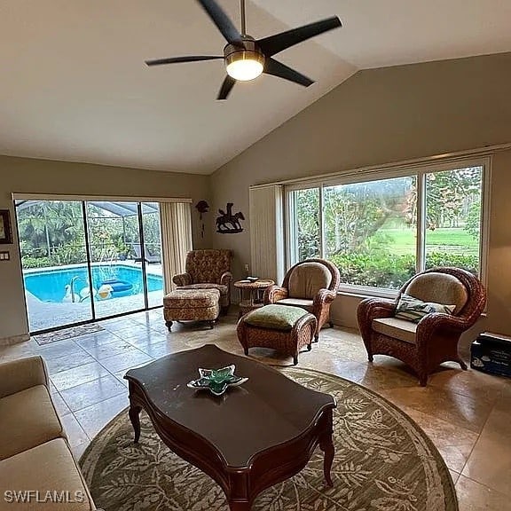 tiled living room featuring ceiling fan and lofted ceiling