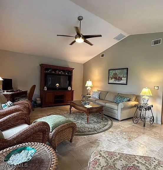 living room featuring ceiling fan and vaulted ceiling