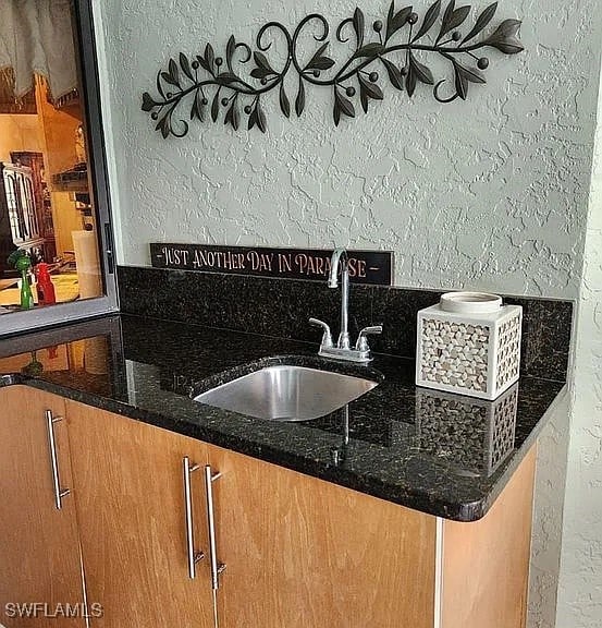 interior space featuring dark stone countertops and sink