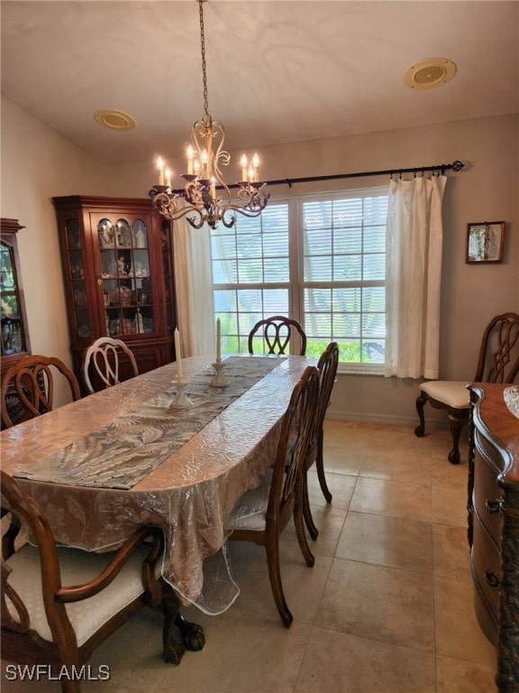 tiled dining area featuring a notable chandelier