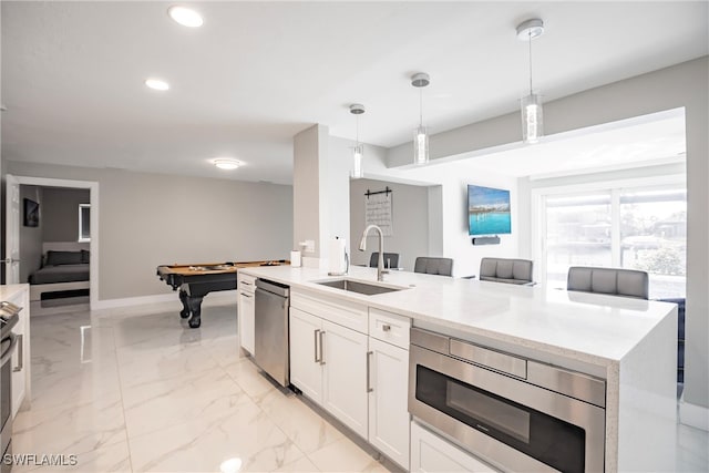 kitchen featuring white cabinets, sink, billiards, hanging light fixtures, and stainless steel appliances