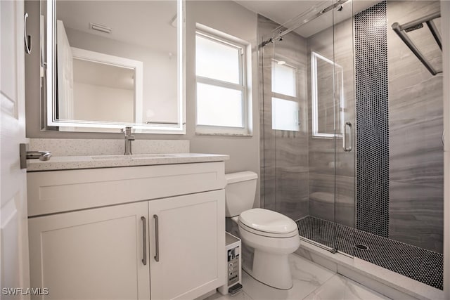 bathroom featuring vanity, toilet, and a shower with door