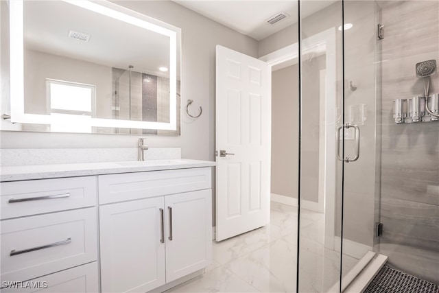 bathroom featuring a shower with door and vanity