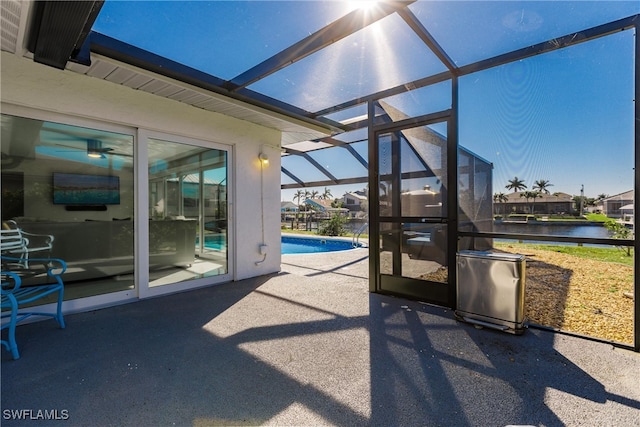 view of patio featuring a lanai and a water view