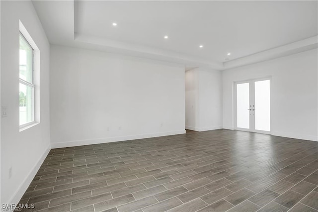 spare room featuring french doors and dark wood-type flooring