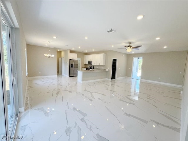 unfurnished living room with ceiling fan with notable chandelier