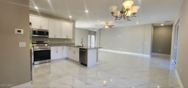 kitchen featuring kitchen peninsula, appliances with stainless steel finishes, sink, pendant lighting, and white cabinetry