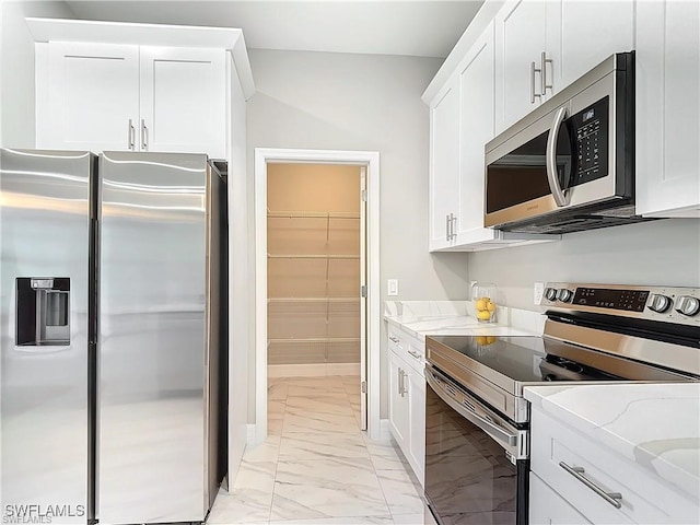 kitchen featuring light stone counters, white cabinets, and appliances with stainless steel finishes