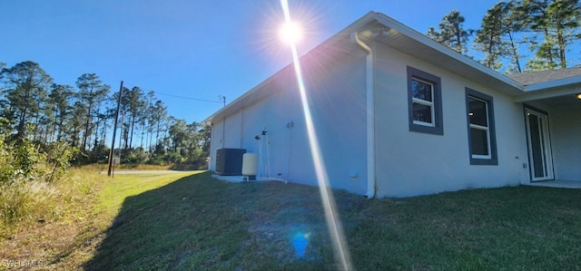 view of home's exterior with a yard and central AC