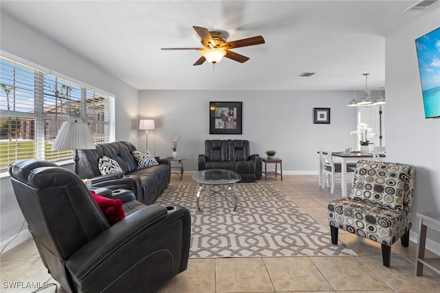 living room with light tile patterned floors and ceiling fan with notable chandelier