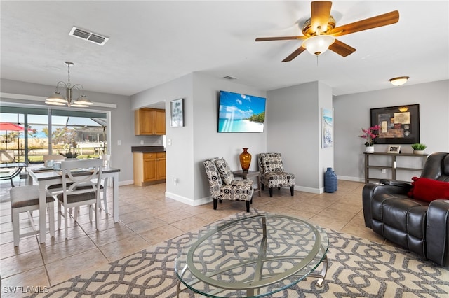 living room featuring ceiling fan with notable chandelier and light tile patterned flooring