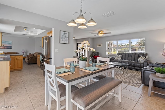 tiled dining space with ceiling fan with notable chandelier