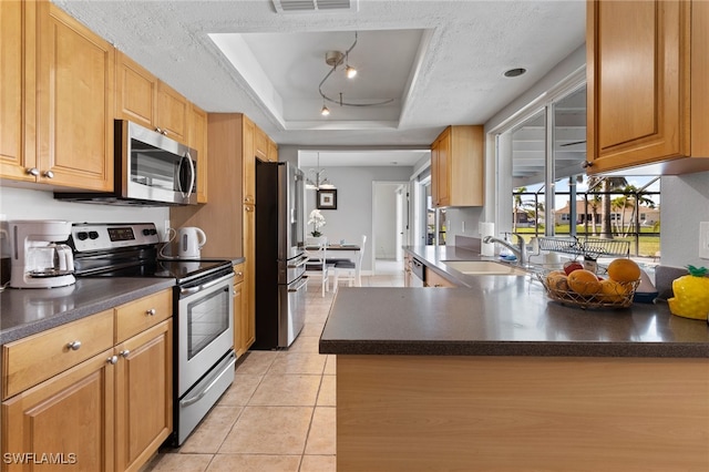 kitchen featuring a raised ceiling, sink, a textured ceiling, appliances with stainless steel finishes, and kitchen peninsula