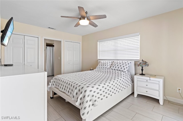 bedroom featuring ceiling fan and two closets