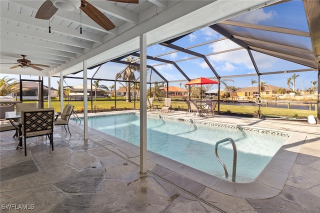 view of swimming pool featuring a lanai, a yard, and a patio