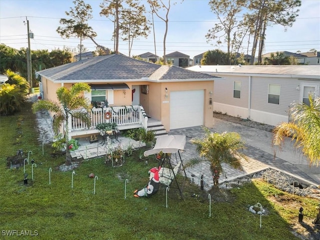 view of front of home featuring a porch, a garage, and a front yard