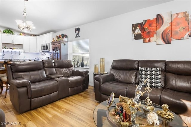 living room with a notable chandelier and light hardwood / wood-style floors